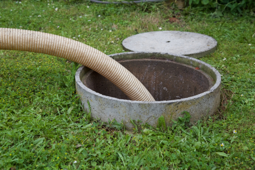 a hose thrown into a septic tank to clean the insides